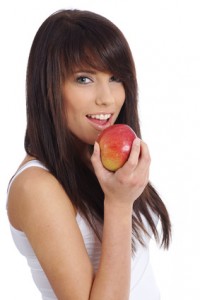 young woman holding  apple. Isolated over white